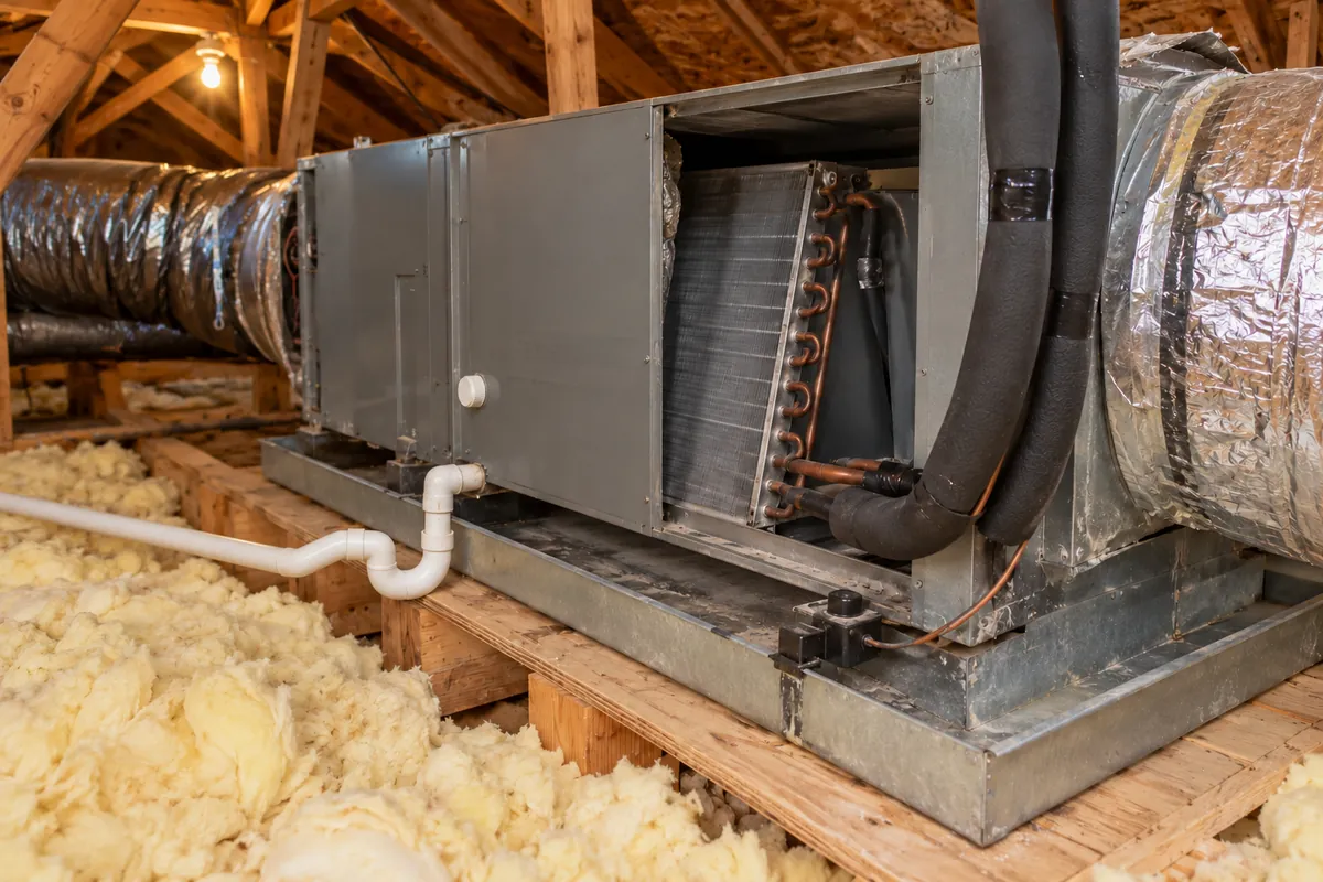 Attic air handler with its panel open, flexible ducts and insulation, attic mold remediation in Oklahoma City, OK